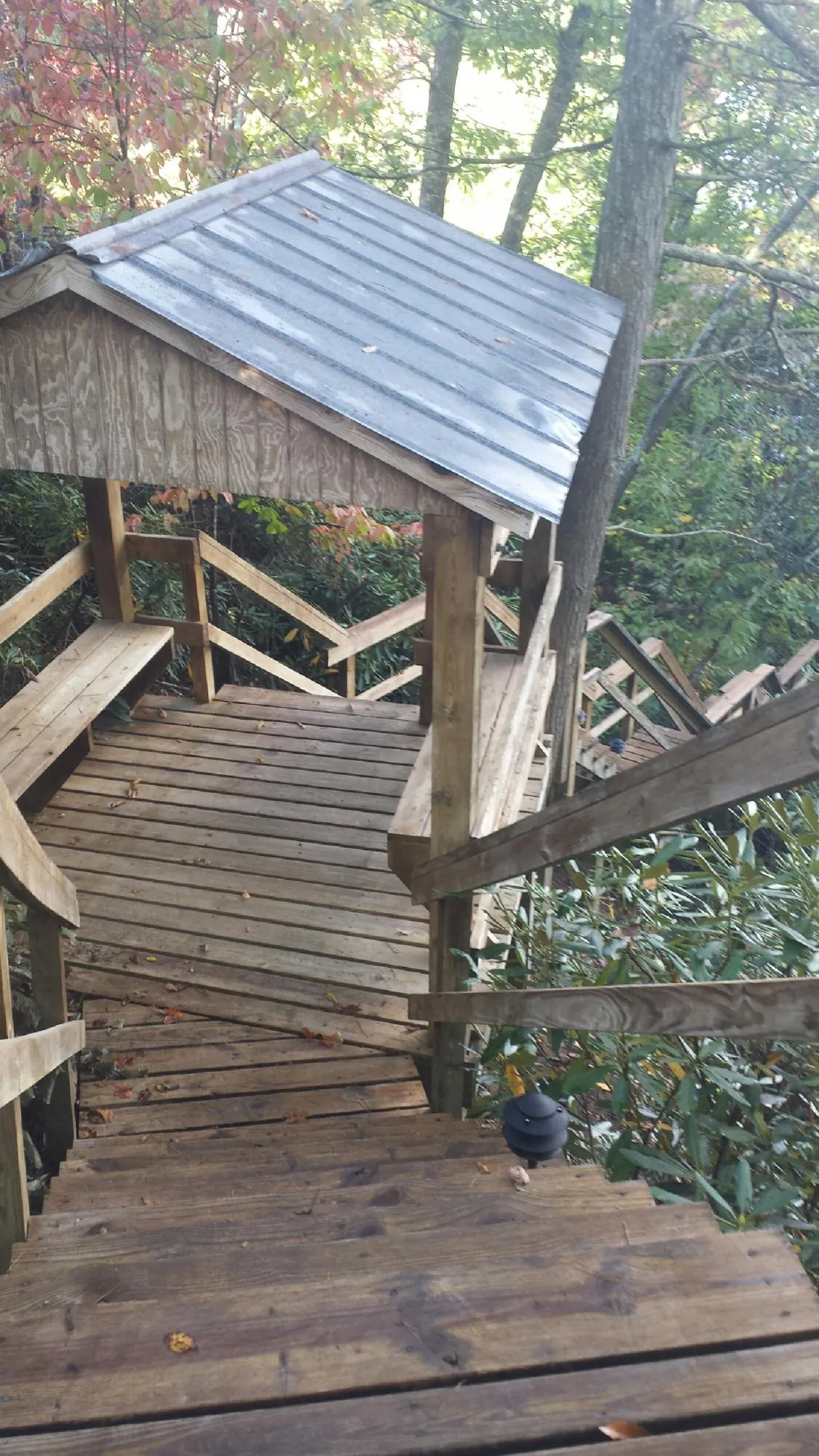 Metal roofed shelter over wooden steps on a wooded walkway — Skylight Repair & Installation work by our crew in Brighton